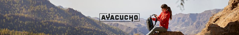Man and woman walking away from old cars wearing Ayacucho gear.