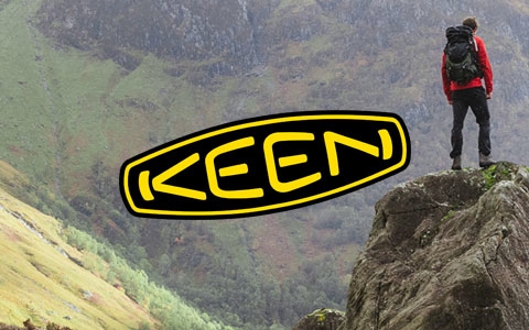 Two people are standing on a rock in Keen boots