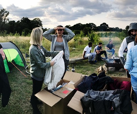 Teenagers are outdoors with boxes of stuff from Outdoor and Cycle Concepts
