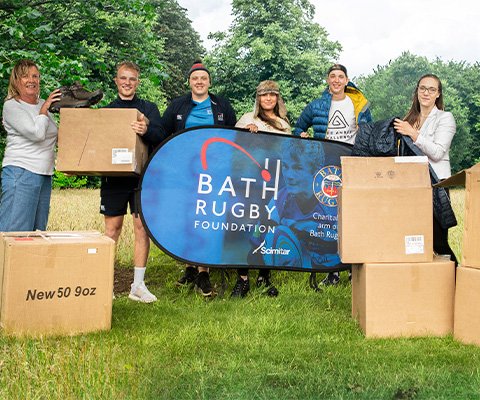 People are standing somewhere outdoors, with boxes in front of them