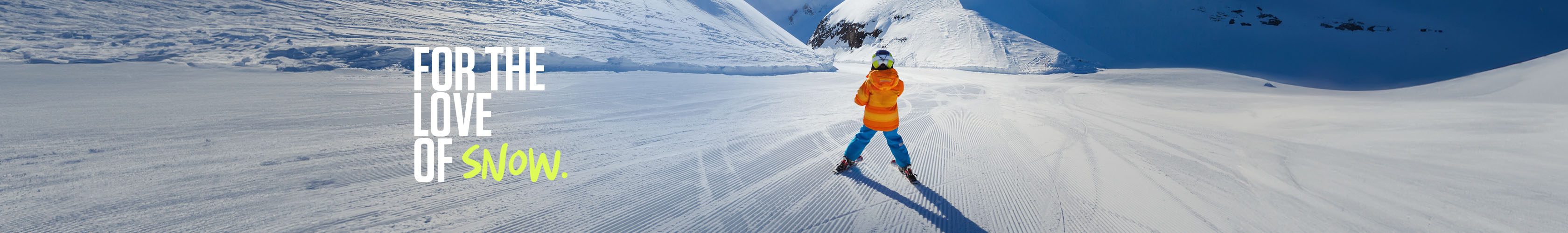 Shop Snow + Rock new season kids. A child in orange jacket and blue troursers skiing down the mountain